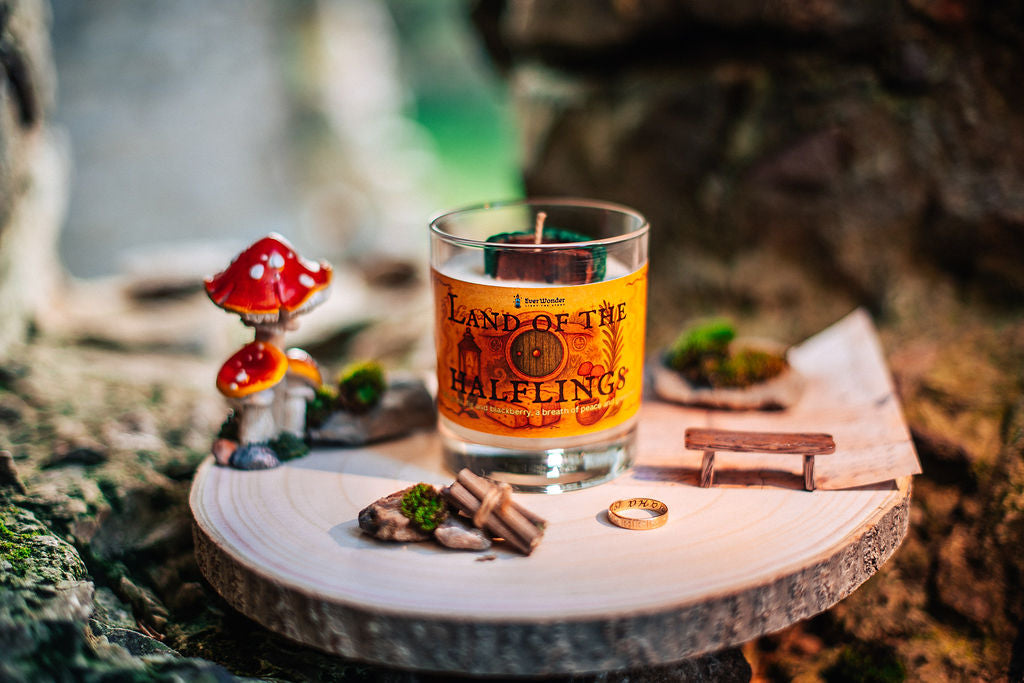 Countryside fantasy candle with warm golden label and hobbit house wax topper