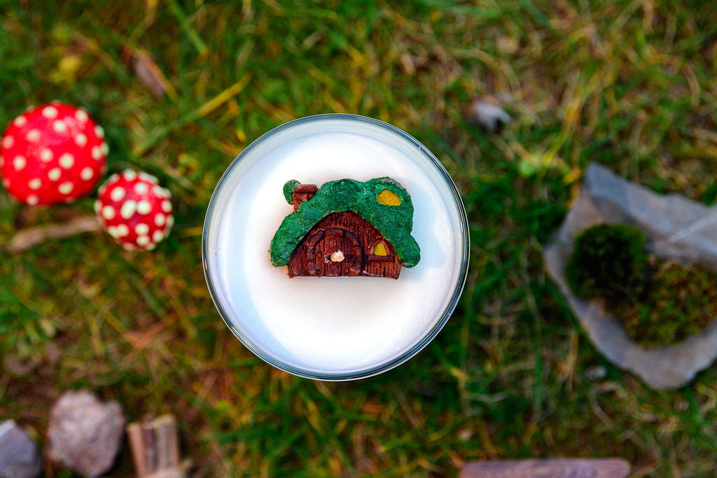 Fantasy candle with miniature hobbit house wax topper inspired by peaceful countryside homes