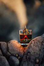 Land of Shadow dark fantasy candle with smoky cedarwood fragrance styled among volcanic rocks